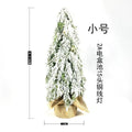 Small 24 inch artificial Christmas tree with lights and snow effect on a desktop