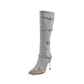 Women's grey knee-high boots with thin high heels on a wooden floor