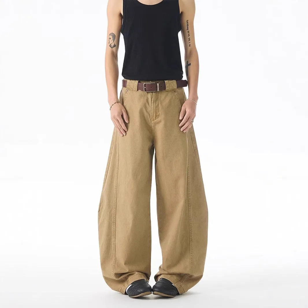 Man wearing brown loose-fit straight leg jeans with a mid waist and button fly.