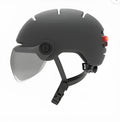Cycling helmet with built-in red LED tail light and brake light on the back, shown in M and L sizes.
