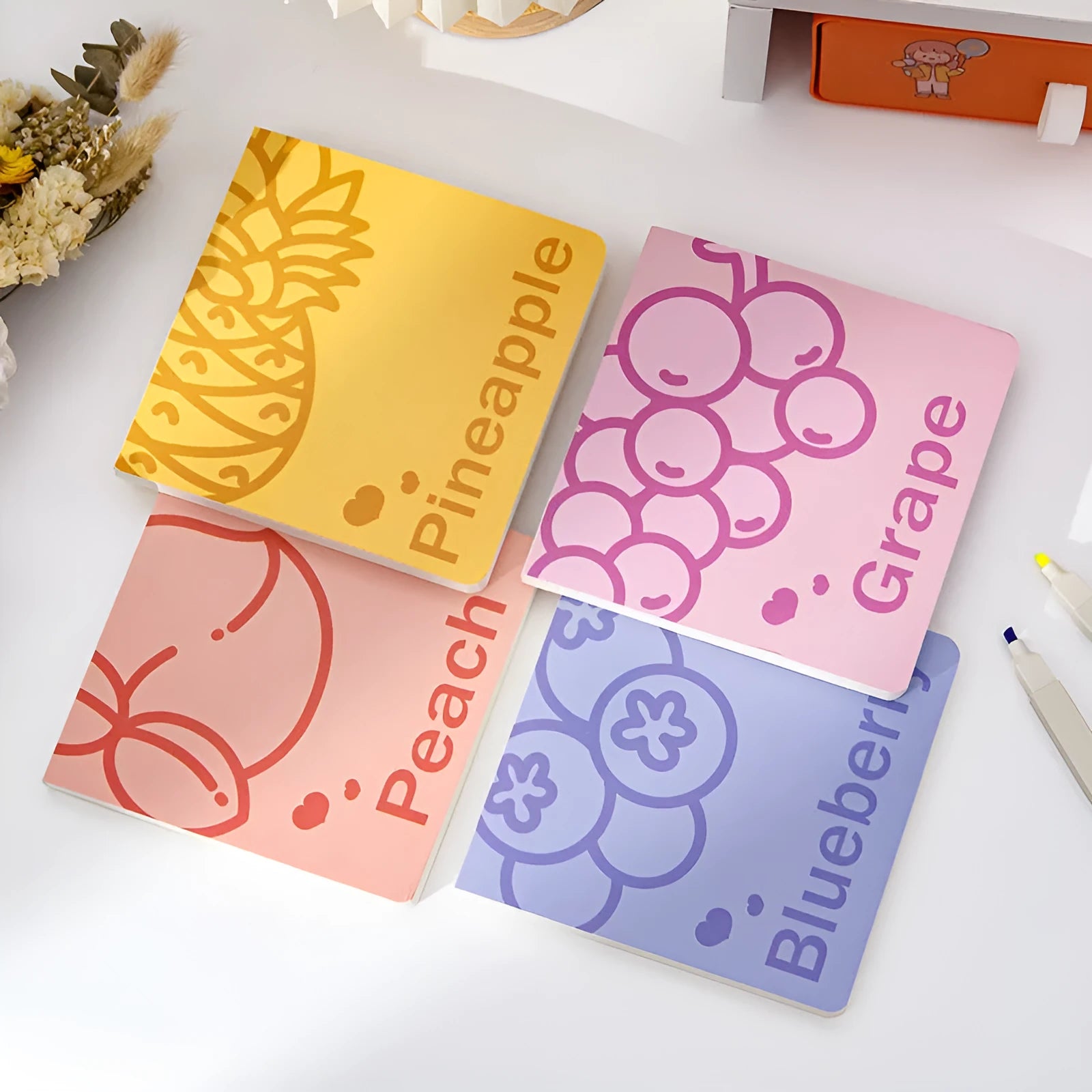 Square notebook with fruit-embossed cover showing pineapple, blueberry, grape, or peach designs, sized 14.5 cm