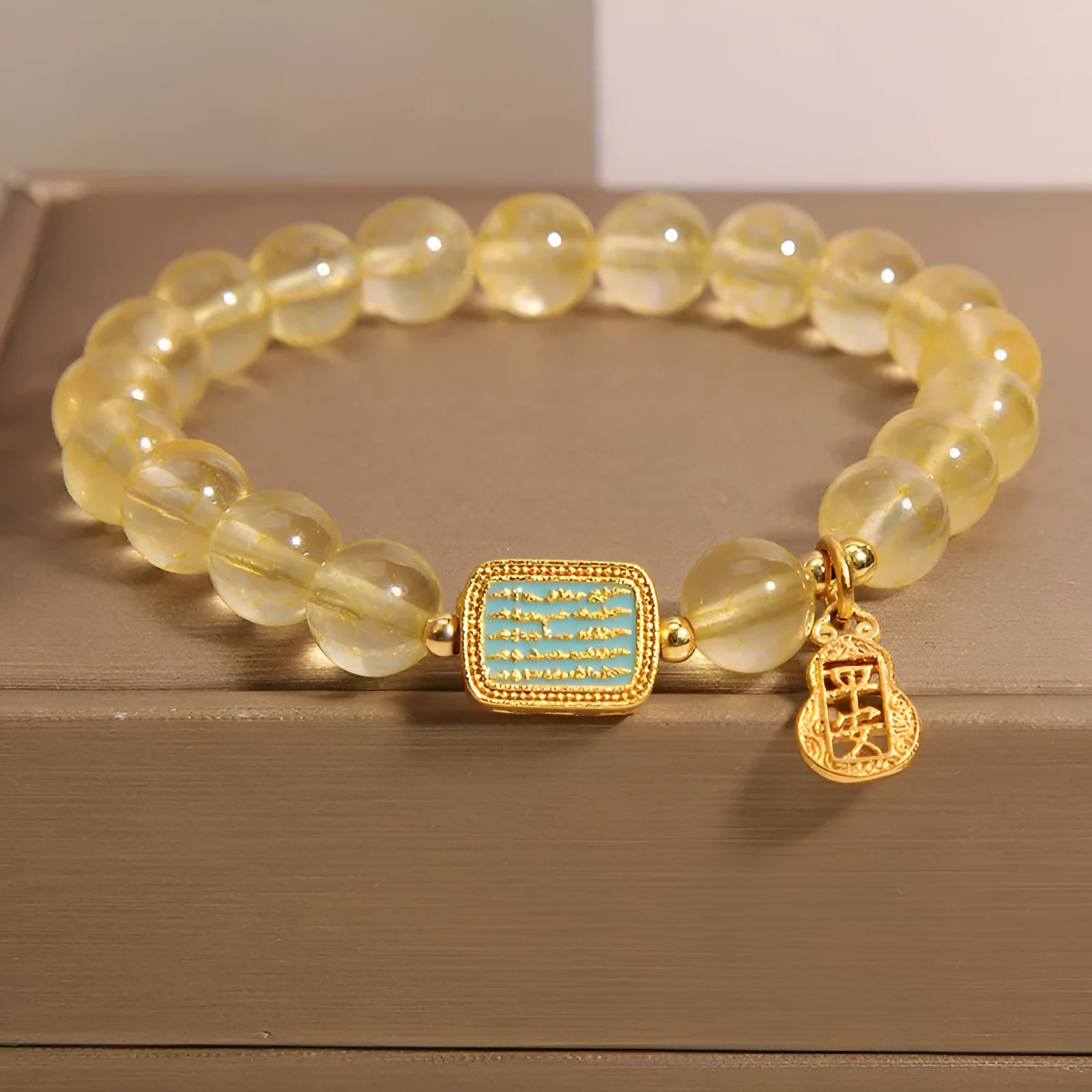 Women's bracelet with yellow citrine stones and sparkling rhinestone details on a white background.