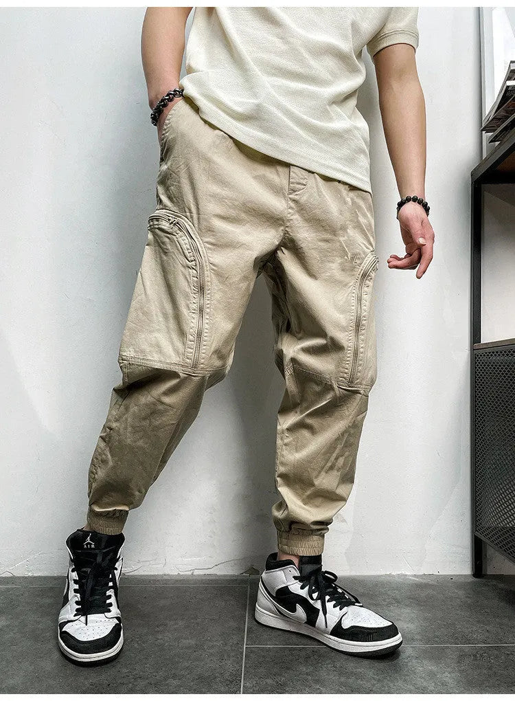 Men's elastic waist cotton cargo trousers with zippered pockets, loose fit, in khaki colour on plain background