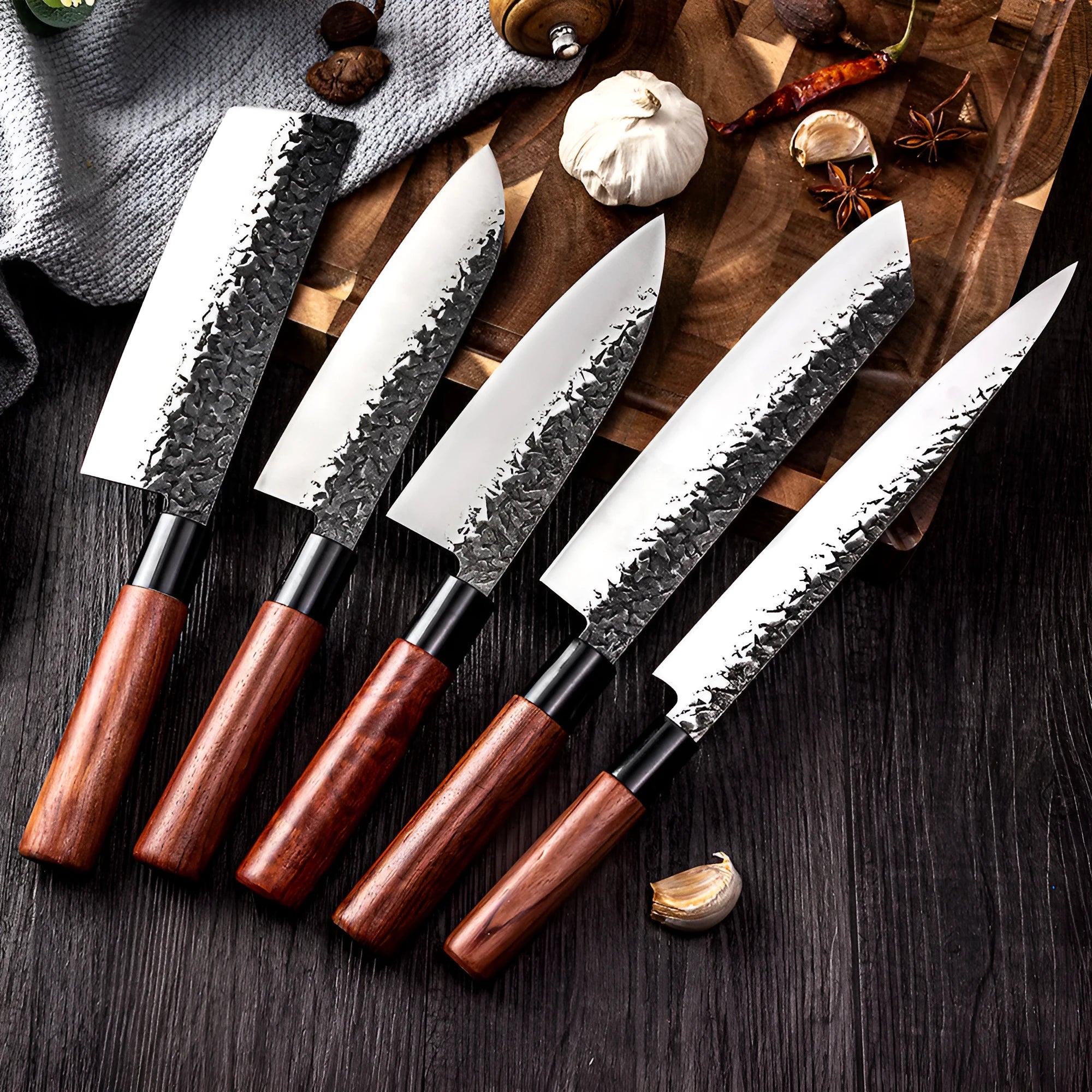 Handmade hammered forged stainless steel santoku chef knife with gift box packaging on a kitchen surface