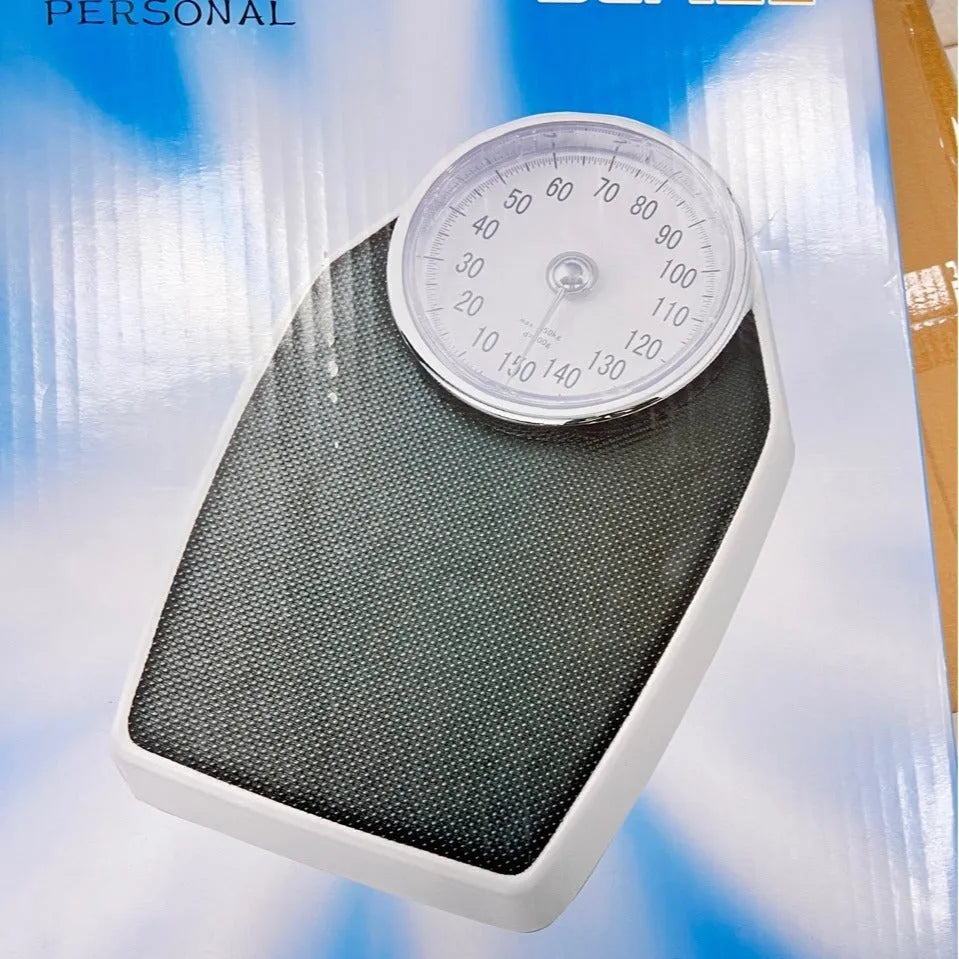 Black mechanical bathroom scale with large analogue dial showing weight measurement