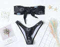Black women's one-piece swimsuit with bikini print and split tube top backless design.
