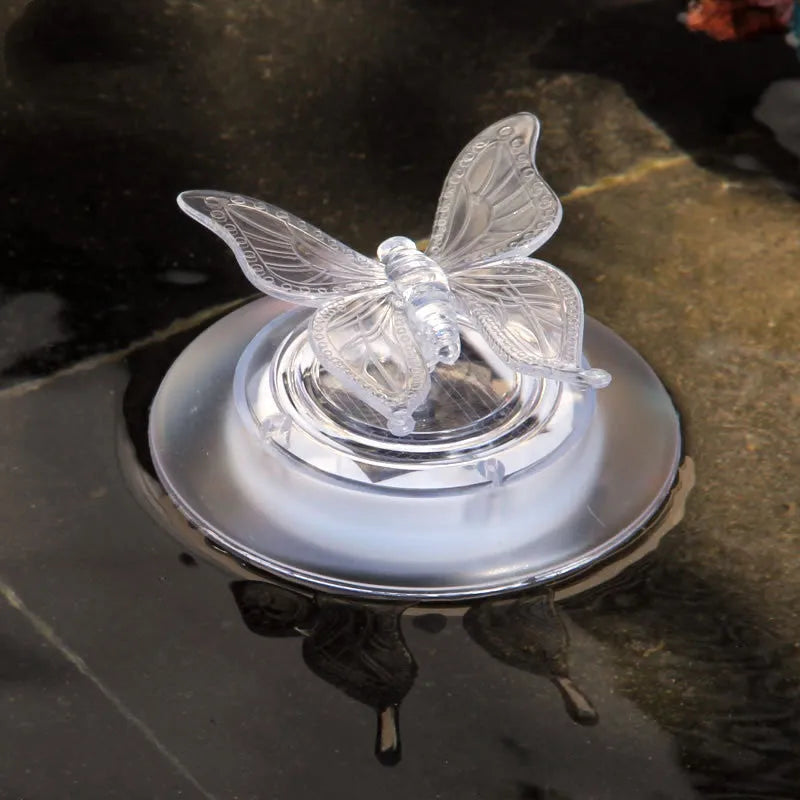 Solar LED float lamp with dragonfly ornament floating on pond water showing 7 colour changing lights