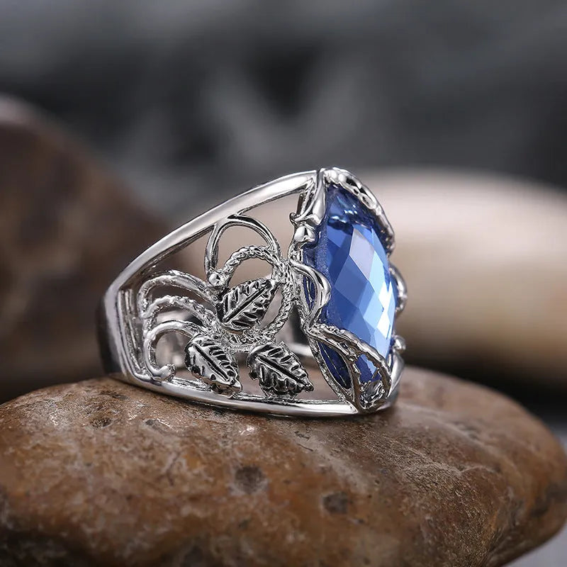 Blue horse eye shaped crystal ring for women on a hand, showing its geometric alloy design.