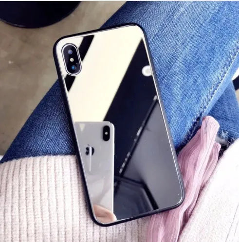 Black iPhone case with a mirrored back panel, shown next to an iPhone.