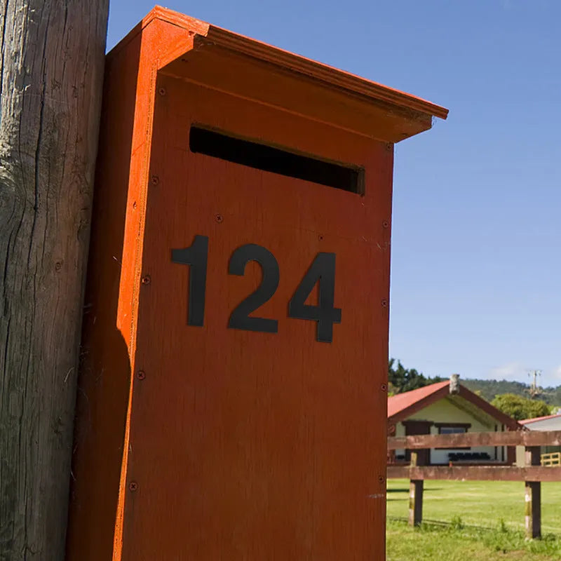 Black stainless steel sticky house number showing 7.5cm height on a door.