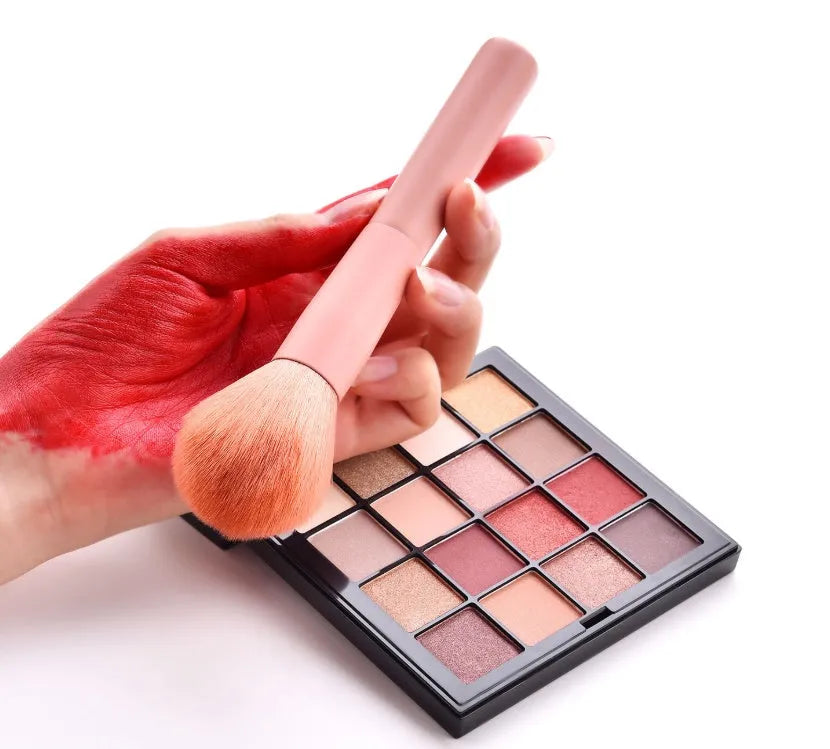 Ten professional makeup brushes with pink painted wooden handles and nylon bristles, including powder, foundation, and double-ended brushes.