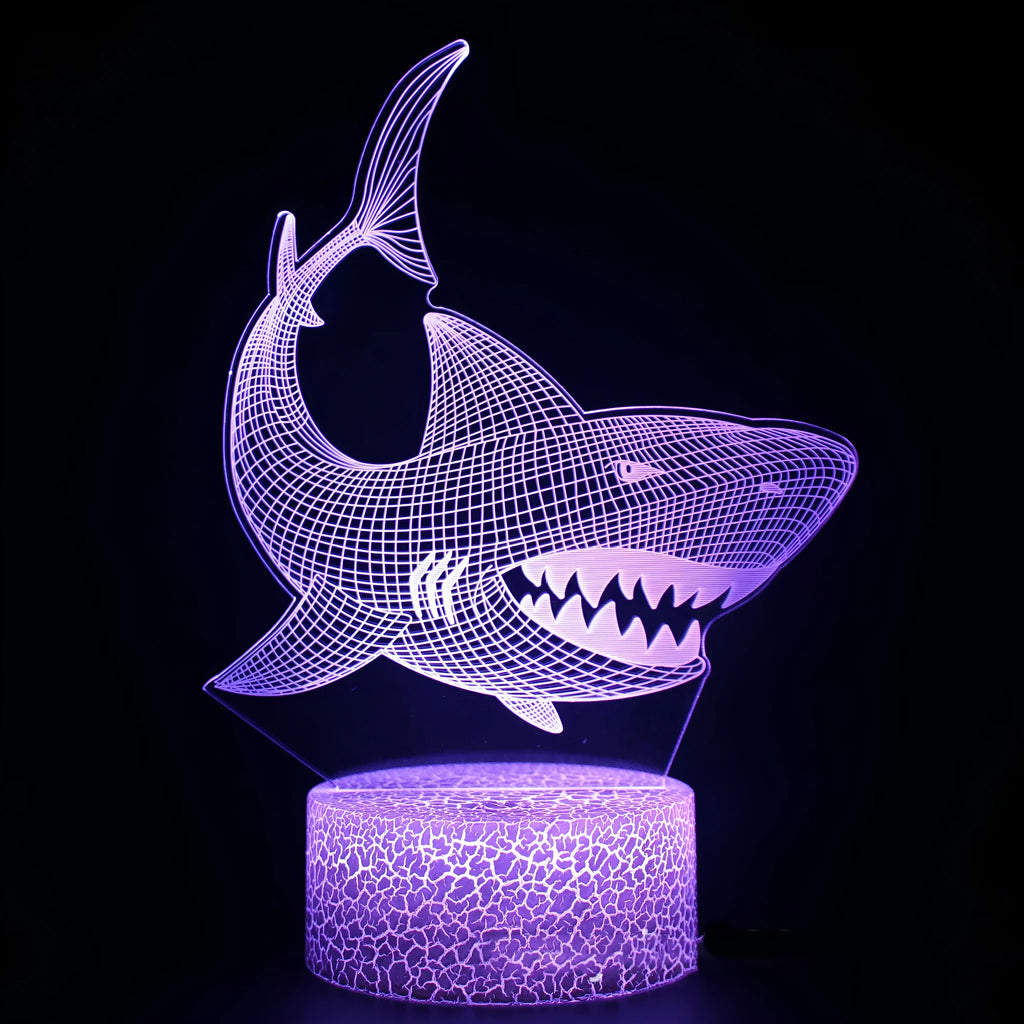 3D sculpted shark LED table lamp on a desk, showing its blue glow and remote control.