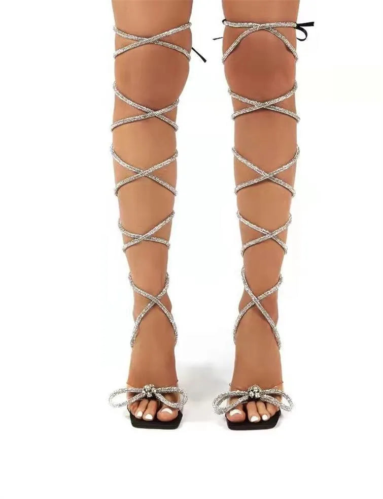 Plus size black strappy sandals with rhinestone details and a square toe on a rubber sole.