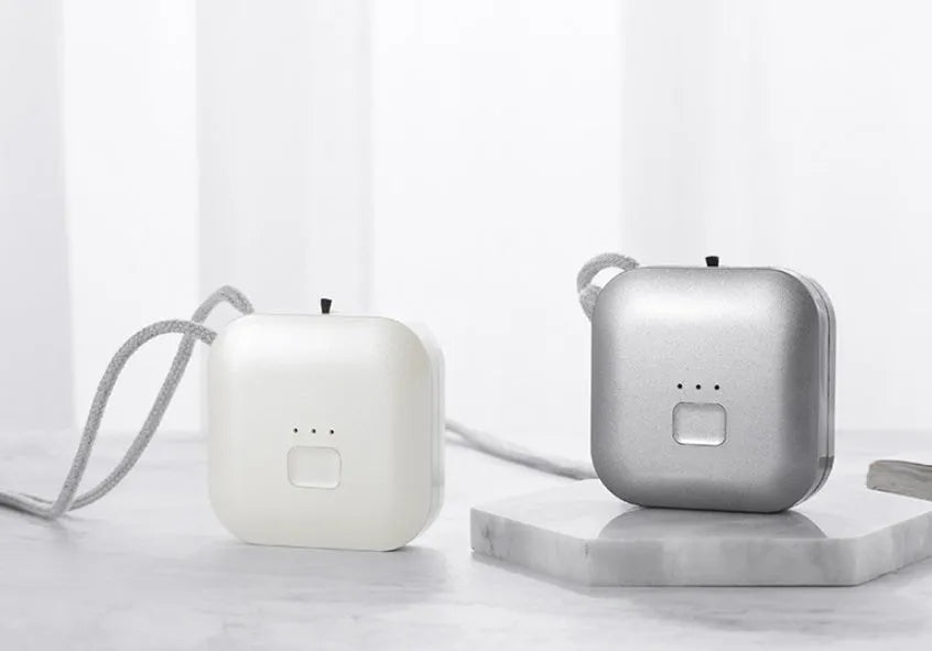 Mini USB portable air purifier necklace in pink, showing compact design with single button.