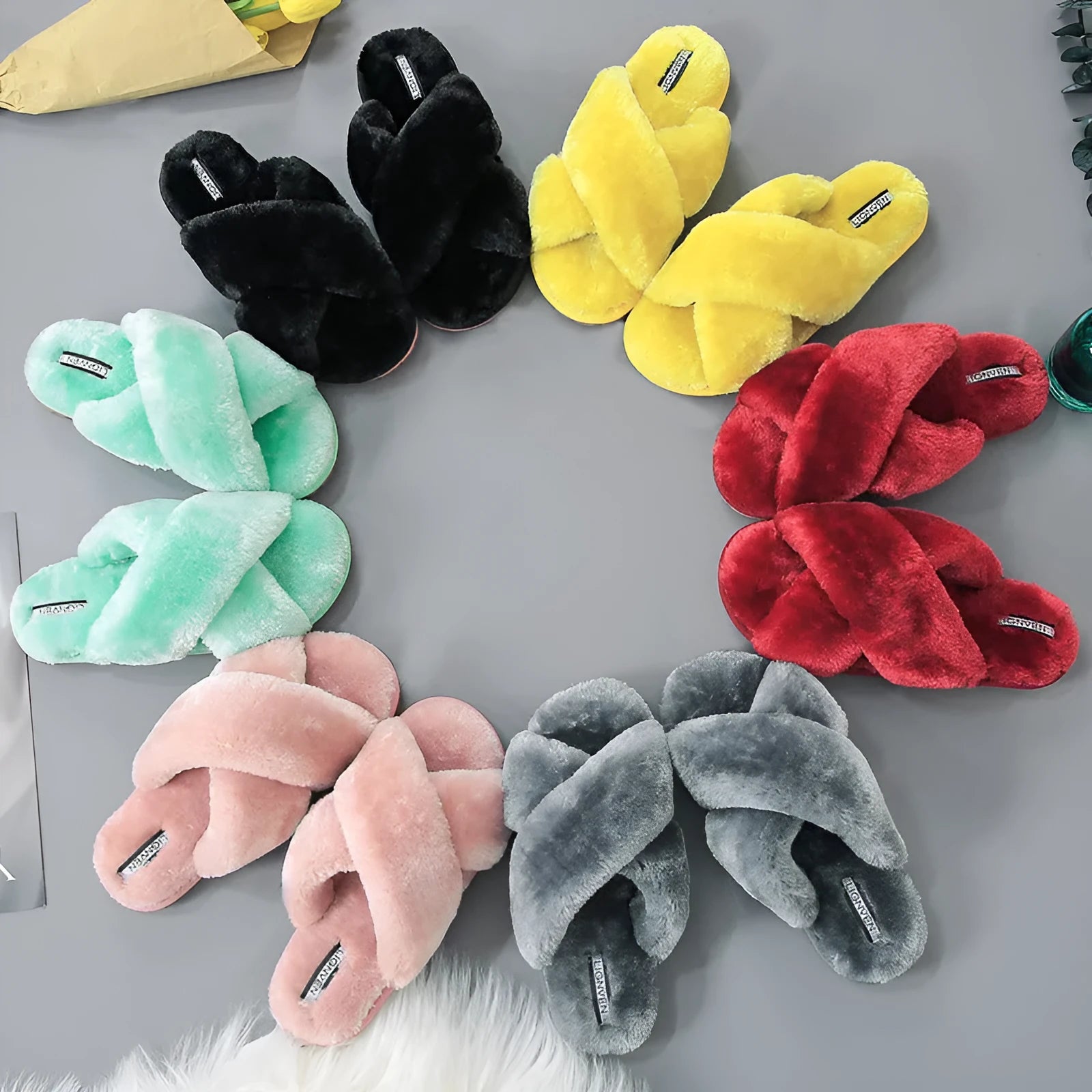 Women's black cross open-toe fur slippers showing the patterned non-slip sole and strap design.