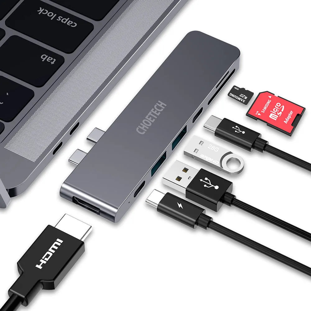 Silver aluminium 7-in-1 USB-C hub adapter with SD card slot, HDMI, USB 3.0, and charging ports.