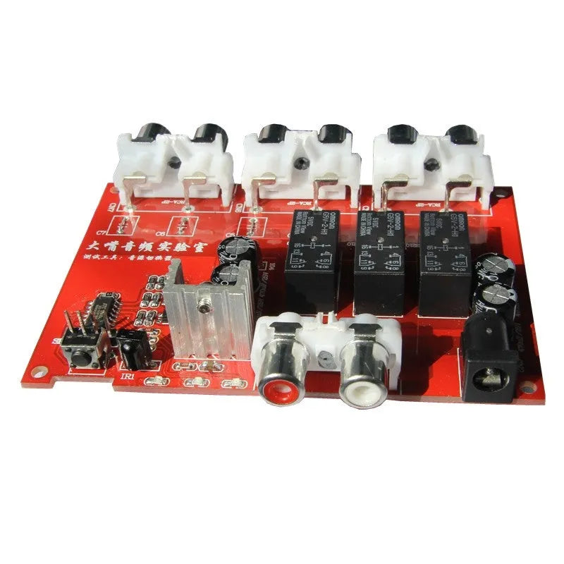 Silver aluminium audio source selector switch unit with front-panel buttons and infrared remote control.
