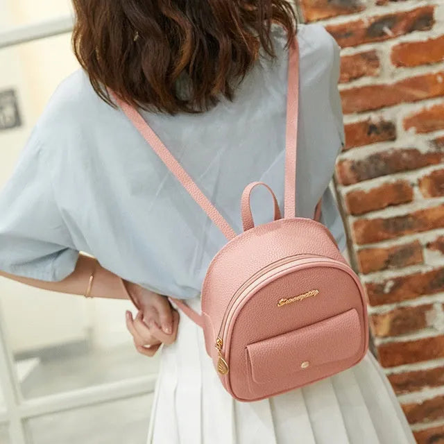 Small black PU women's backpack purse shown as a shoulder bag, with zipper closure and compact size.