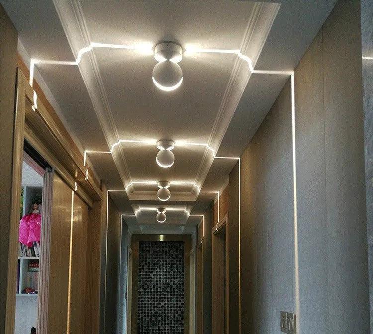 Modern aluminium LED spotlight bar wall lamp with glass lens, shown illuminating a corridor.