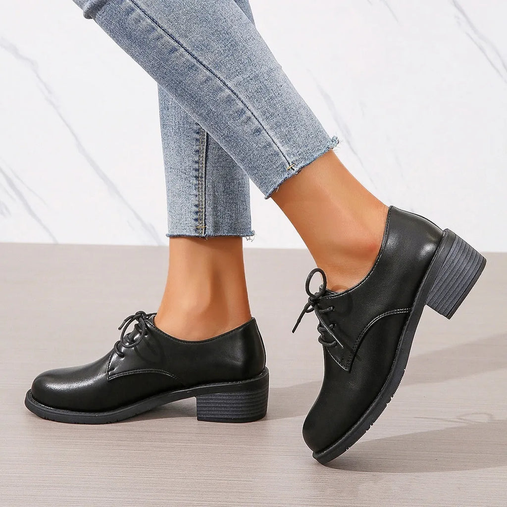 Black women's lace-up work shoes with a thick chunky heel and soft rubber sole.