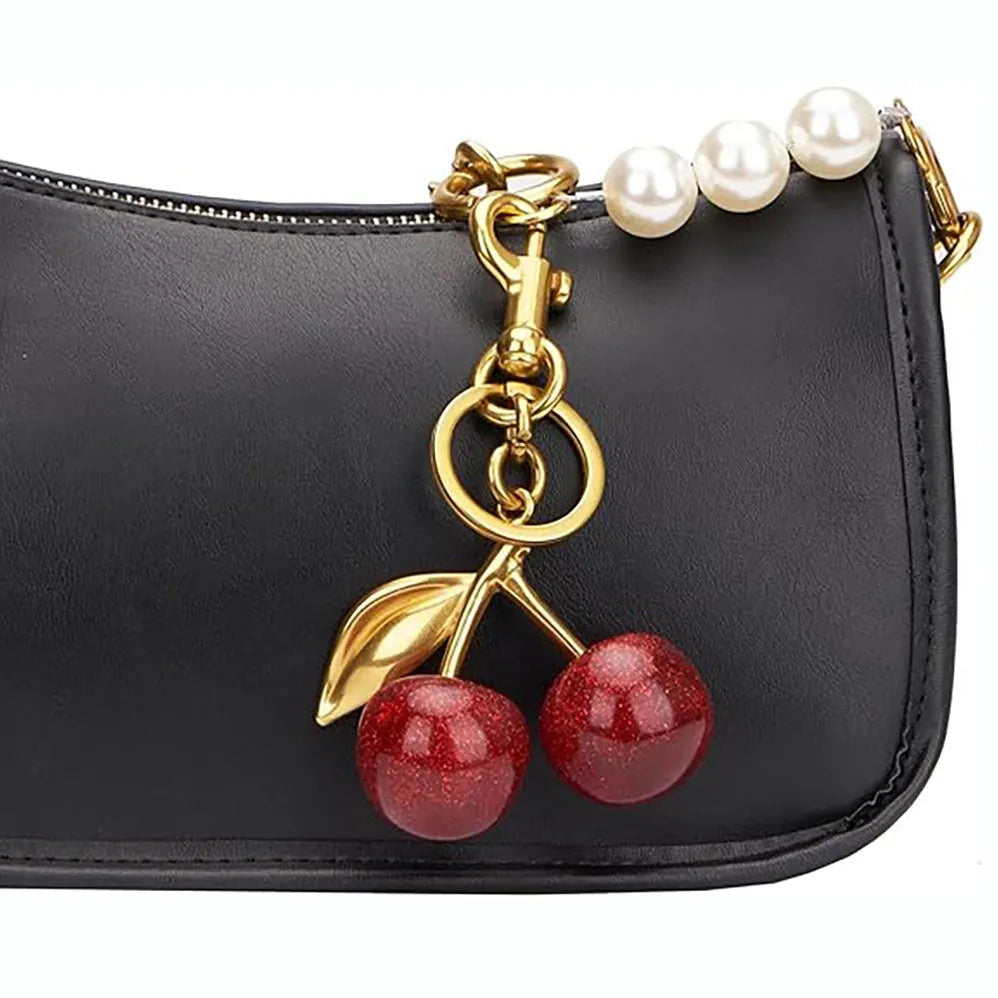 Close-up of a red zinc alloy keychain pendant shaped like a detailed three-dimensional cherry.
