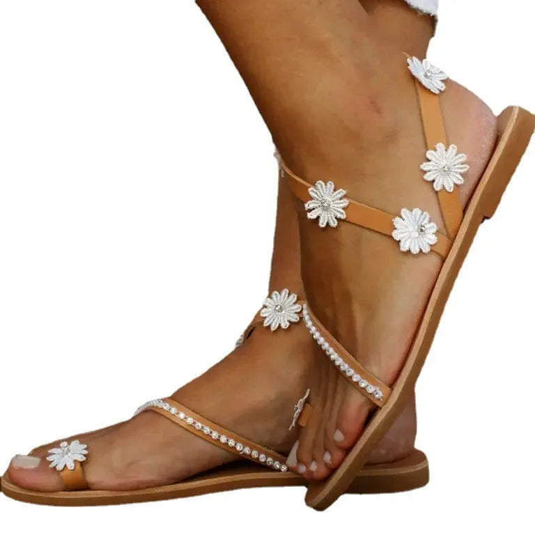 Brown women's flat sandals with flower detail and herringbone toe pattern on rubber sole.