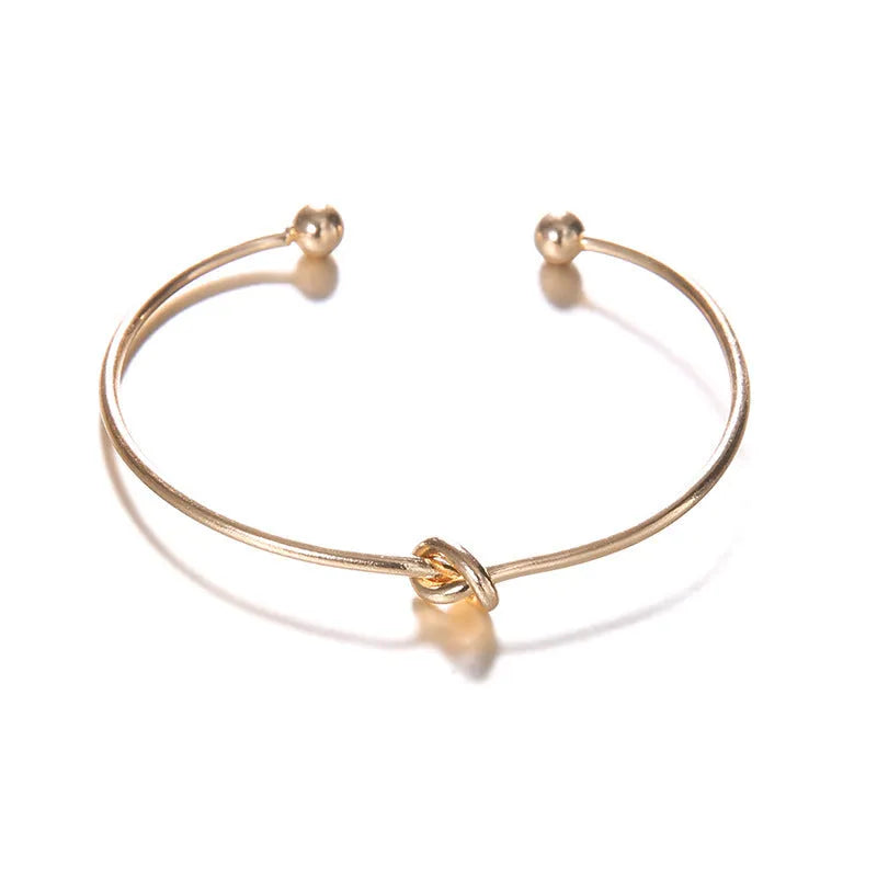 Gold vintage cuff bracelet for women with an arrow knot design detail.