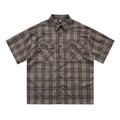 Men's black and brown plaid short sleeve shirt with embroidered lettering and lapel collar.
