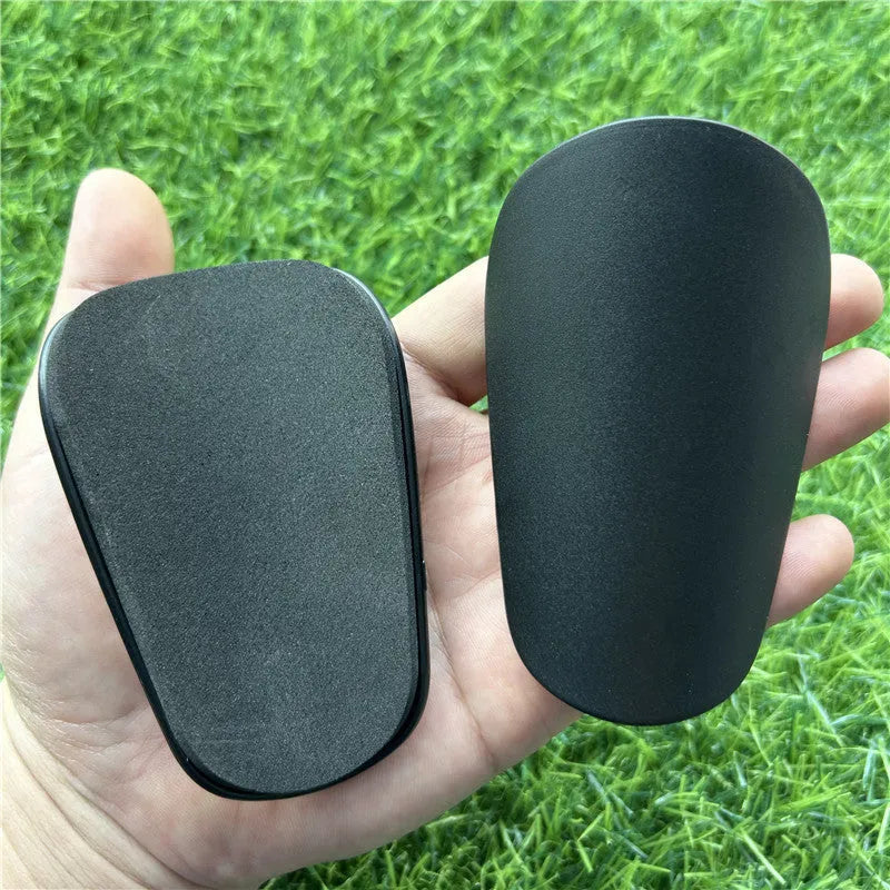 Extra small plastic football shin guards measuring 8cm by 5cm with elastic straps