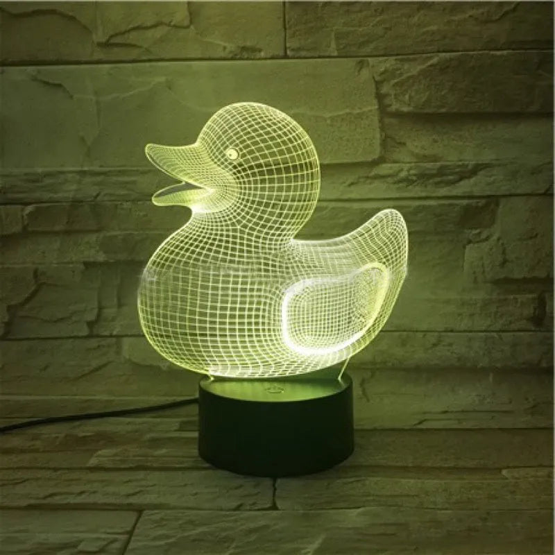 Little yellow duck 3D table night light showing seven colour options on a desk next to its black remote control.