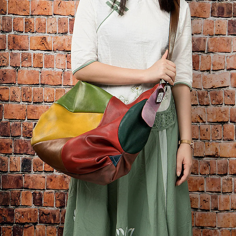 Brown cowhide leather crossbody travel bag open to show space for a laptop and A4 magazines.