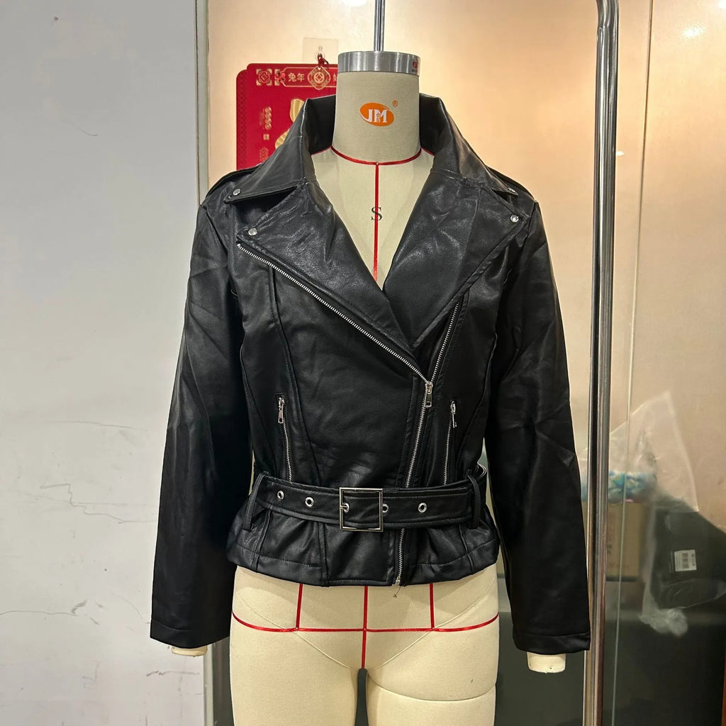 Black punk style jacket with a short belt, lapel, and Peter Pan collar on a hanger.