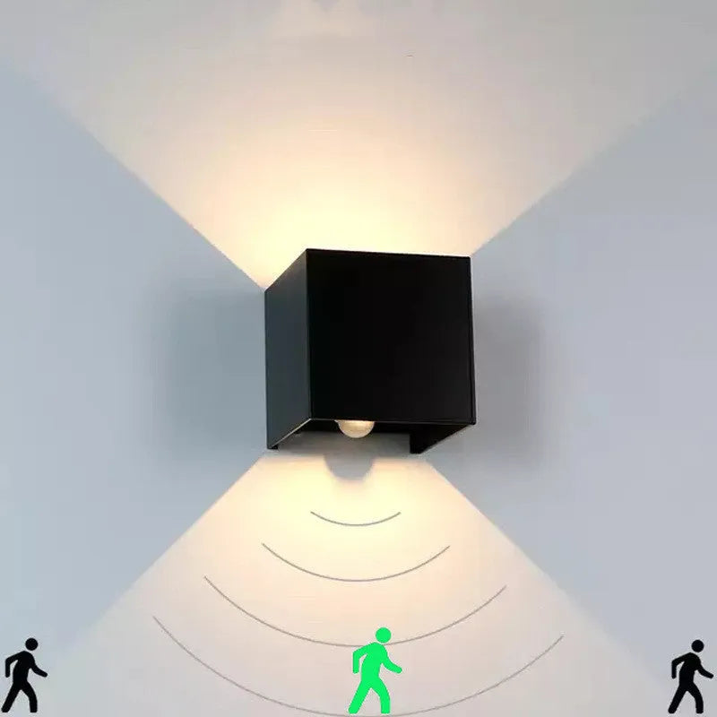 Square black aluminium alloy LED wall lamp mounted on a brick wall, showing 360-degree light emission.