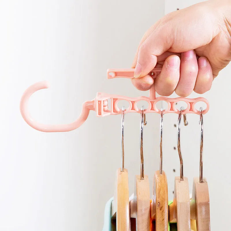 Blue revolving wardrobe hanger with five rotating arms and a handle for clothes organisation.