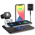 Black wireless charging desk bracket with phone on Qi pad, watch and headphones connected to wired charging ports