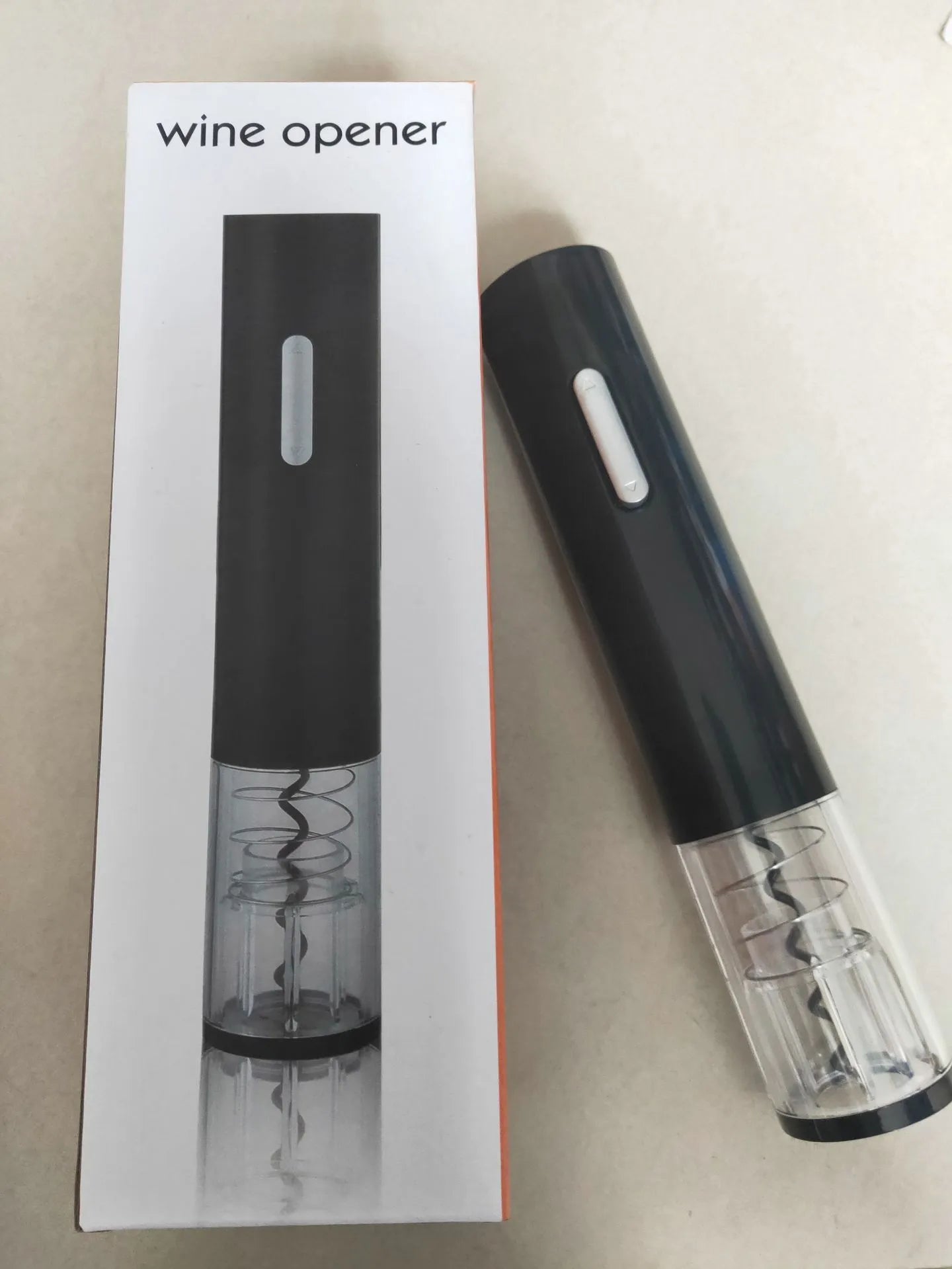 Black automatic electric wine bottle opener with foil cutter on a kitchen counter