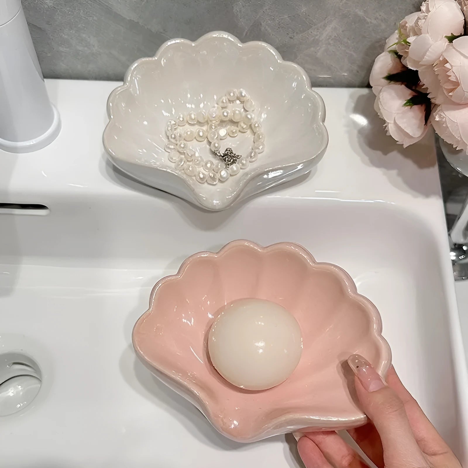 White and pink shell-shaped plastic soap dish for bathroom counter organisation.