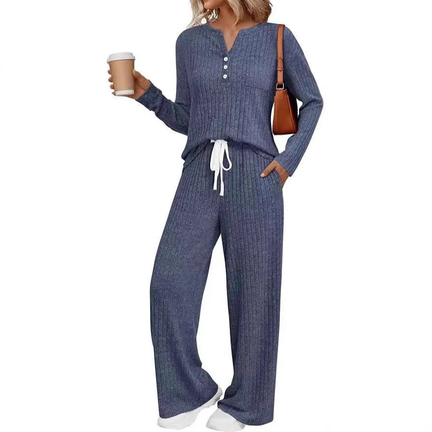 Woman wearing a striped knitted V-neck long coat with matching pants in a light grey colour.