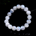 Polished natural blue moonlight moonstone round bead bracelet on white background, showing geometric facets.