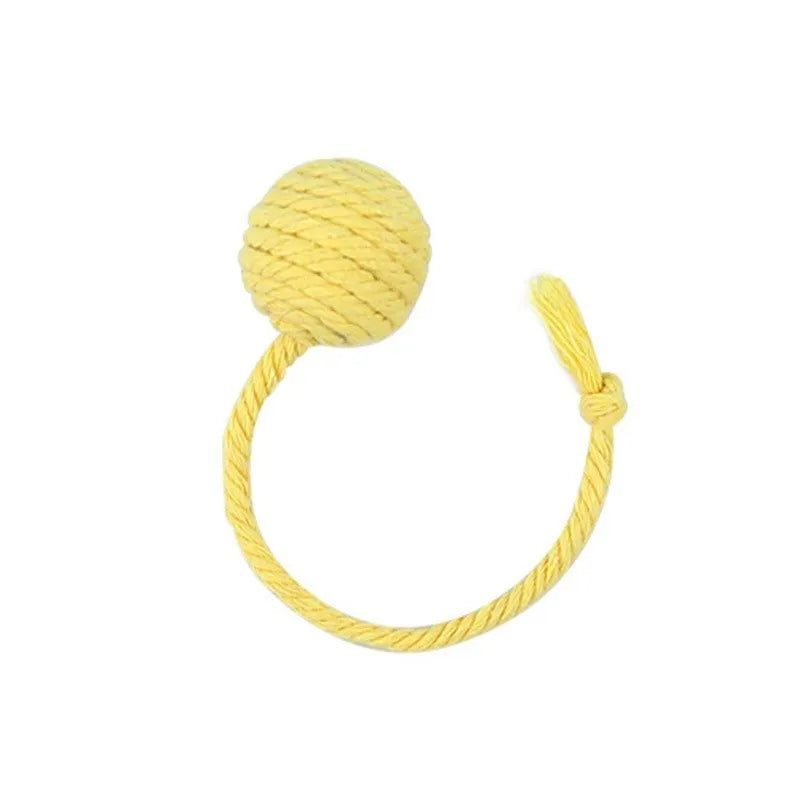 Green cat toy ball with attached rope on a wooden floor, shown next to a yellow 3cm size version.