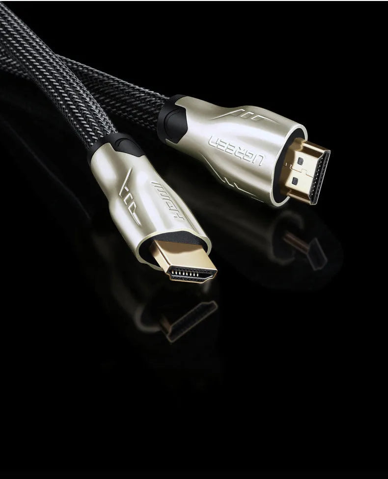 Close-up of a gold-plated HDMI connector on a black cable showing its aluminium foil and braided shielding layers.
