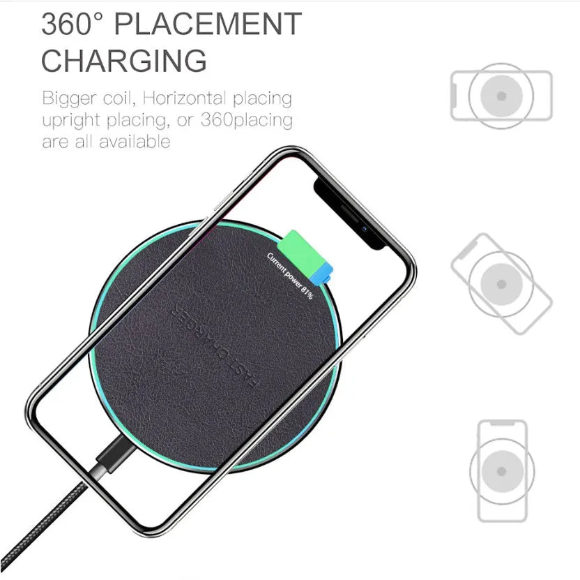 Black Qi wireless charging pad for iPhone 11 on a wooden surface.