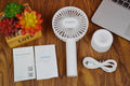 White ORICO FH1 portable USB rechargeable fan with fine line detailing, shown in handheld and desktop positions.