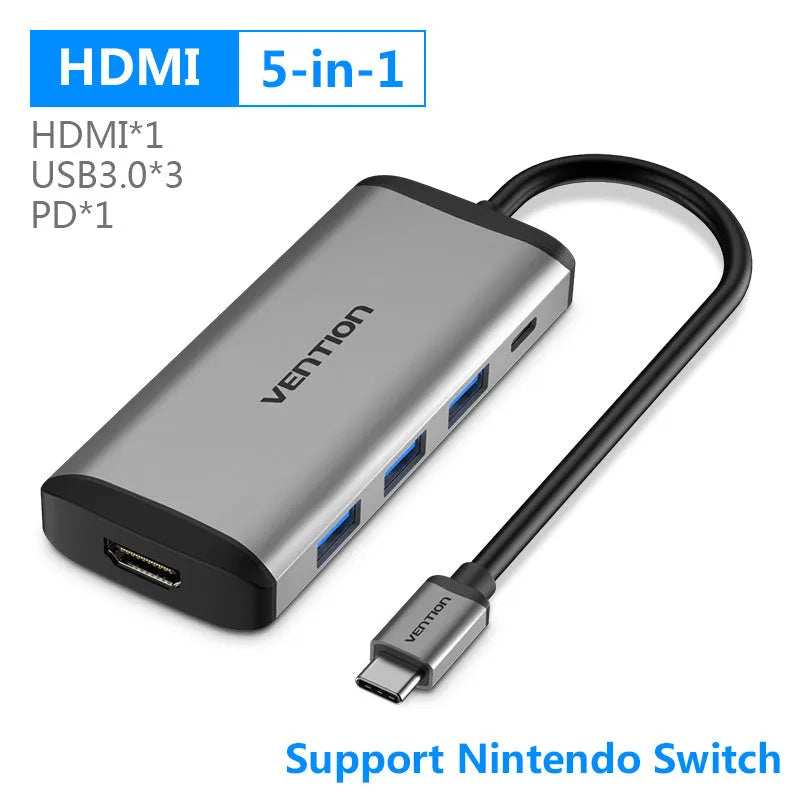 Deep grey USB-C to 6-in-1 hub with HDMI, Ethernet, USB ports, and card slots on a desk.