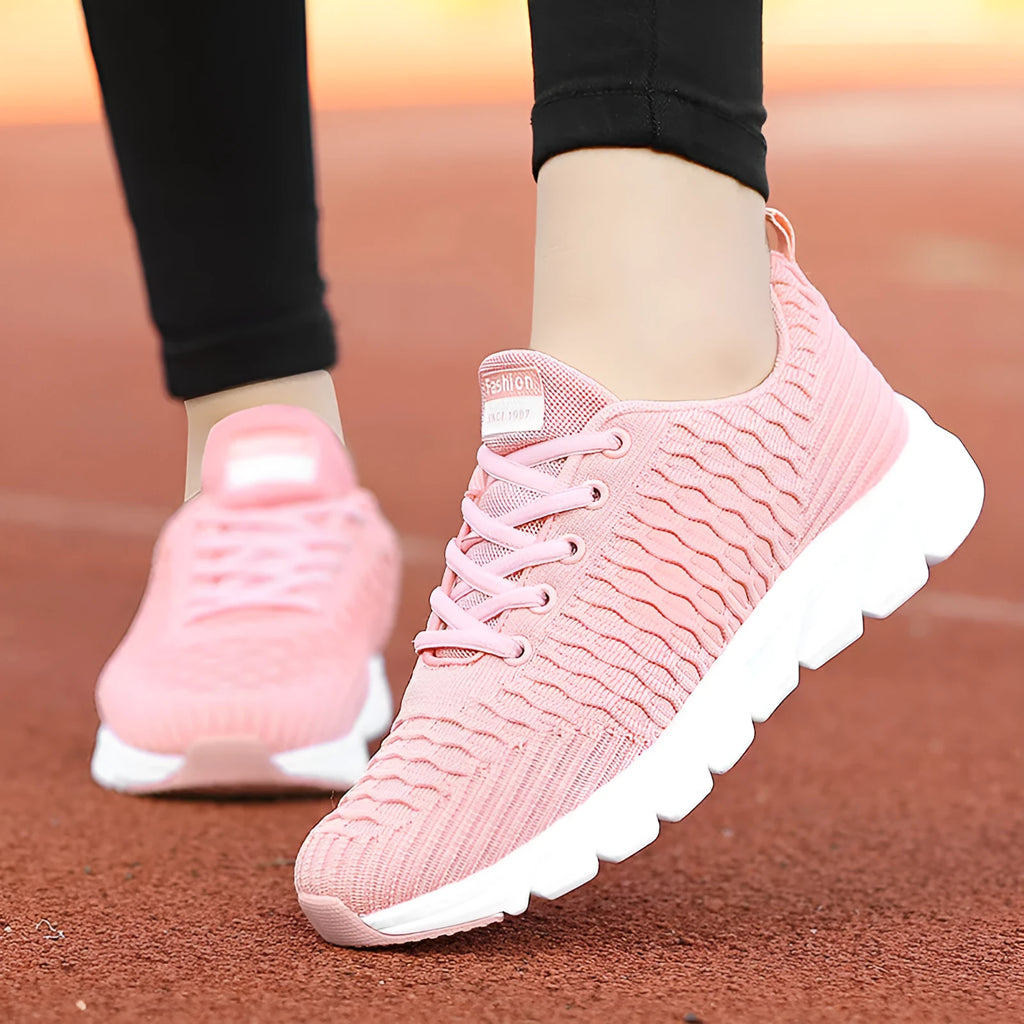 Women's black running shoes with a fly weave upper and a durable outsole on a track.