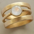 Gold titanium steel ring with hollow geometric design and micro-inlaid white chalcedony stone