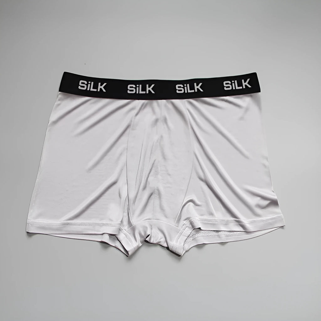 Men's loose fit silk shorts in navy blue, shown in a casual setting