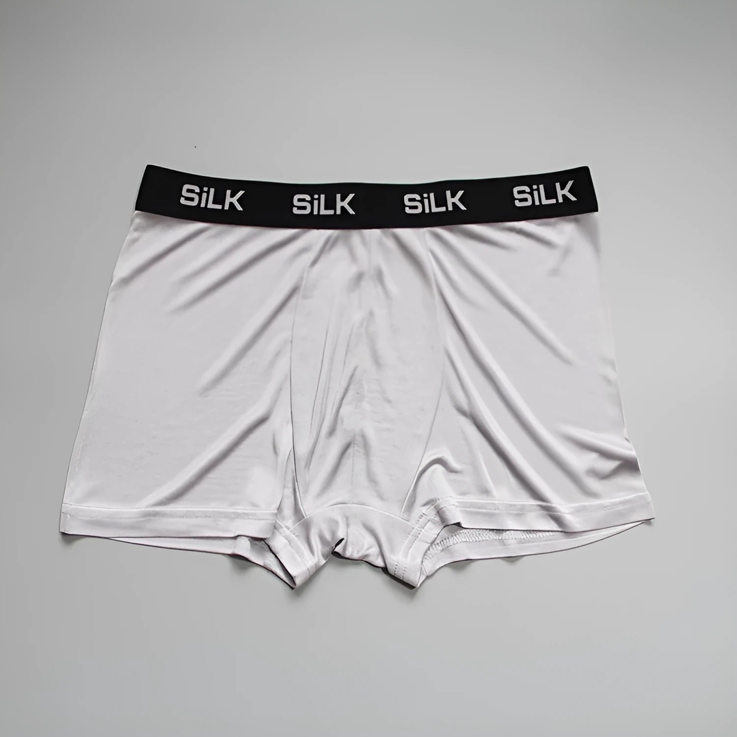 Men's loose fit silk shorts in navy blue, shown in a casual setting