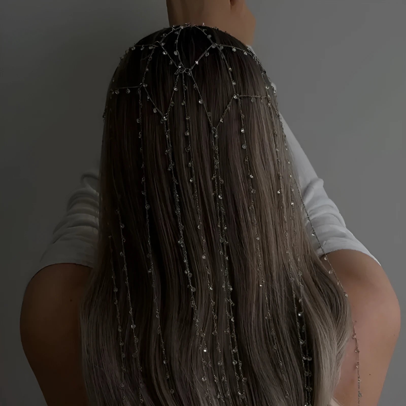 Gold rhinestone mesh headband with a tassel detail on a model's hair.