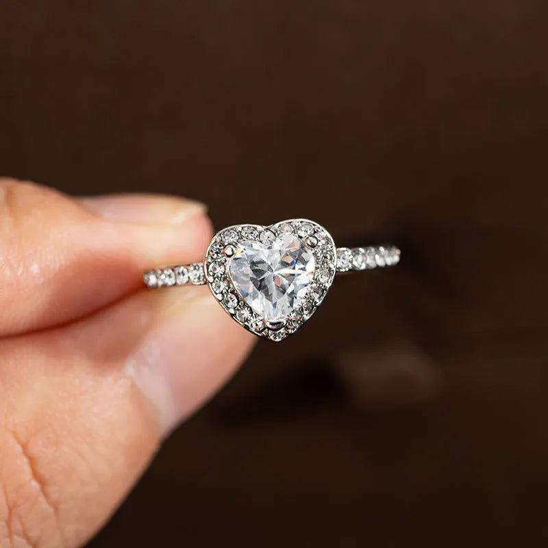 Women's fashion crystal heart-shaped ring in rose gold or silvery on a white background.